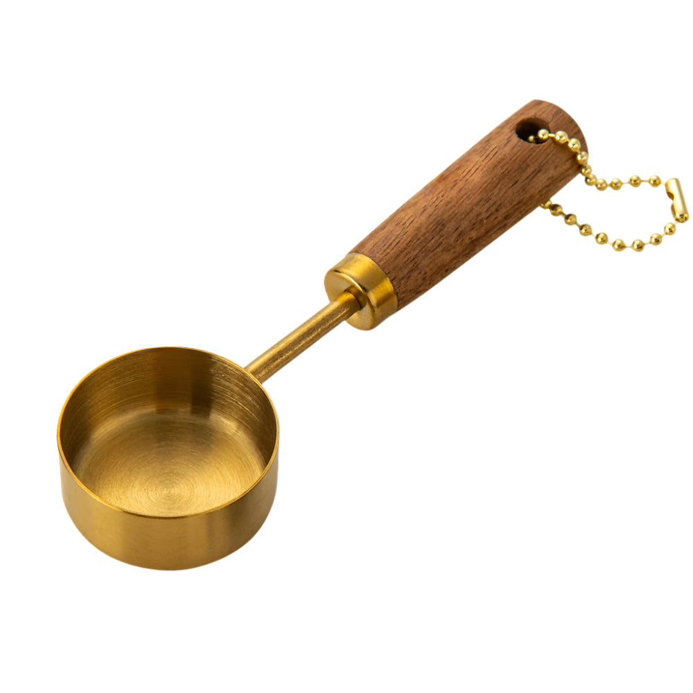 Gold measuring scoop with wooden handle and chain on a white background